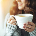 Eine junge Frau mit einer Tasse Tee in der Hand.