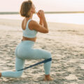 Frau am Ostseestrand, die Workouts-Übungen im Sand macht. ©Adobe Stock, Sviatlana
