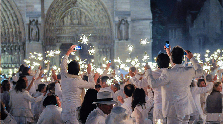 Menschenmenge, die in weiß gekleidet mir Zündstäbchen in Paris das Diner en blanc feiern. ©Adobe Stock, daniel