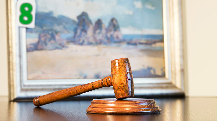 Ein Auktionshammer, der bei einer Kunstauktion vor einem Gemälde liegt. ©Adobe Stock, GDM photo and video