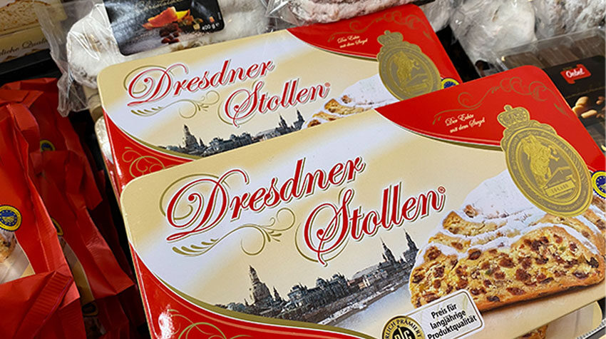 Verpackter Dresdner Stollen in festlicher Kartonverpackung auf einer Auslage im Geschäft.